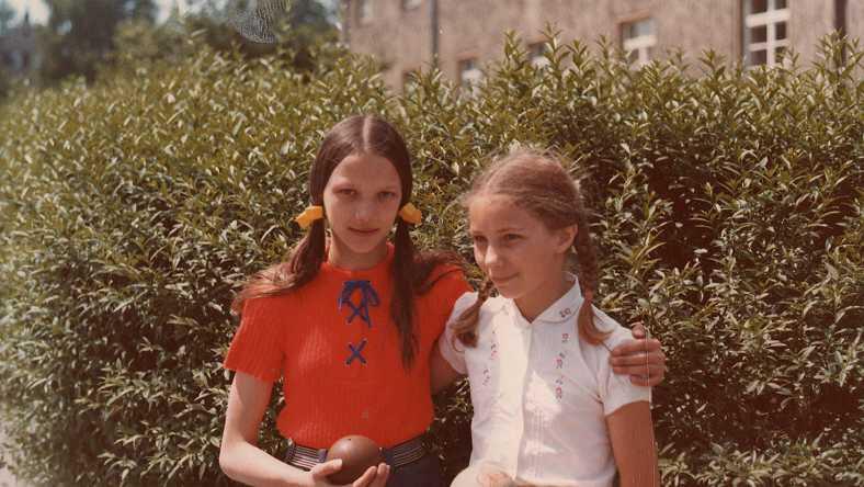 Två flickor står tillsammans framför en buske. Klipp från Eva och Ramona